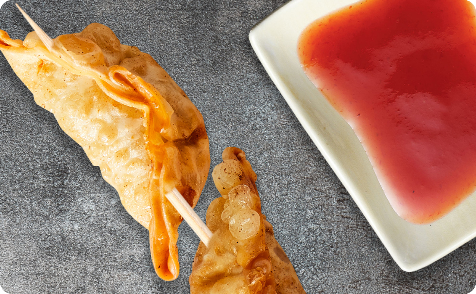 Fried Dumpling Skewer Fried dumplings on a skewer accompanied with dipping sauce.